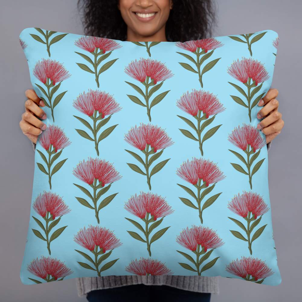 Pohutukawa print cushion with sky blue background being held by a woman