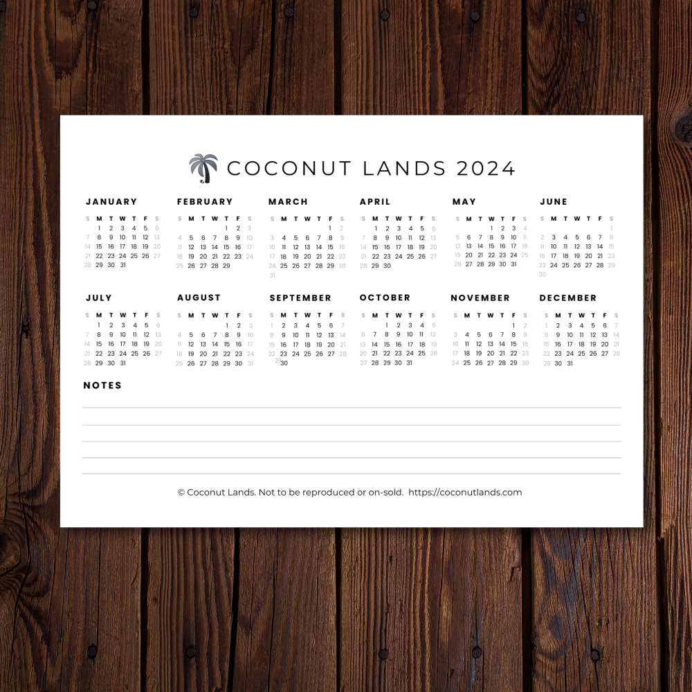 Coconut Lands wall calendar 2024, greyscale version, shown on a wood-panelled wall
