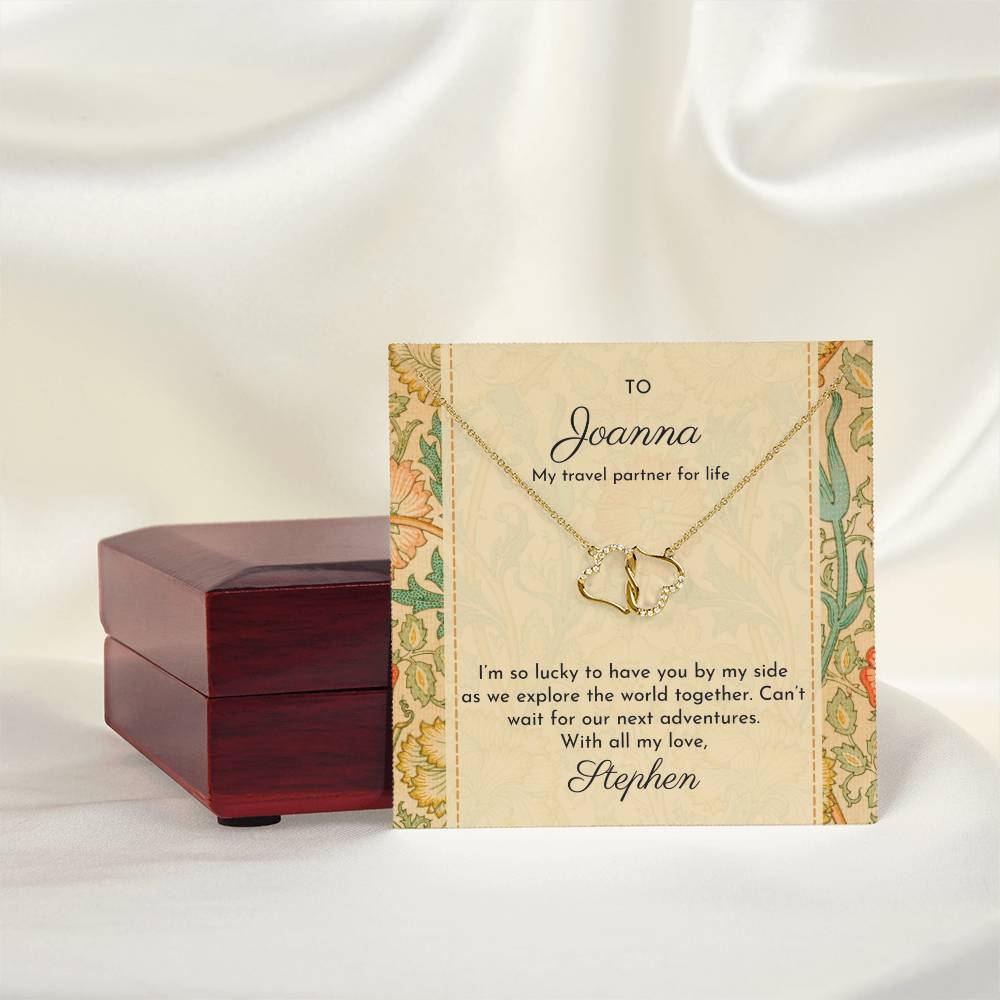 Double hearts solid gold necklace shown with message card featuring William Morris 'Pink and rose' design, shown next to mahogany-style luxury gift box