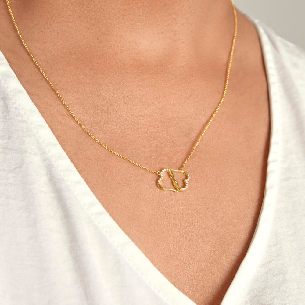 Double hearts solid gold necklace worn by a woman