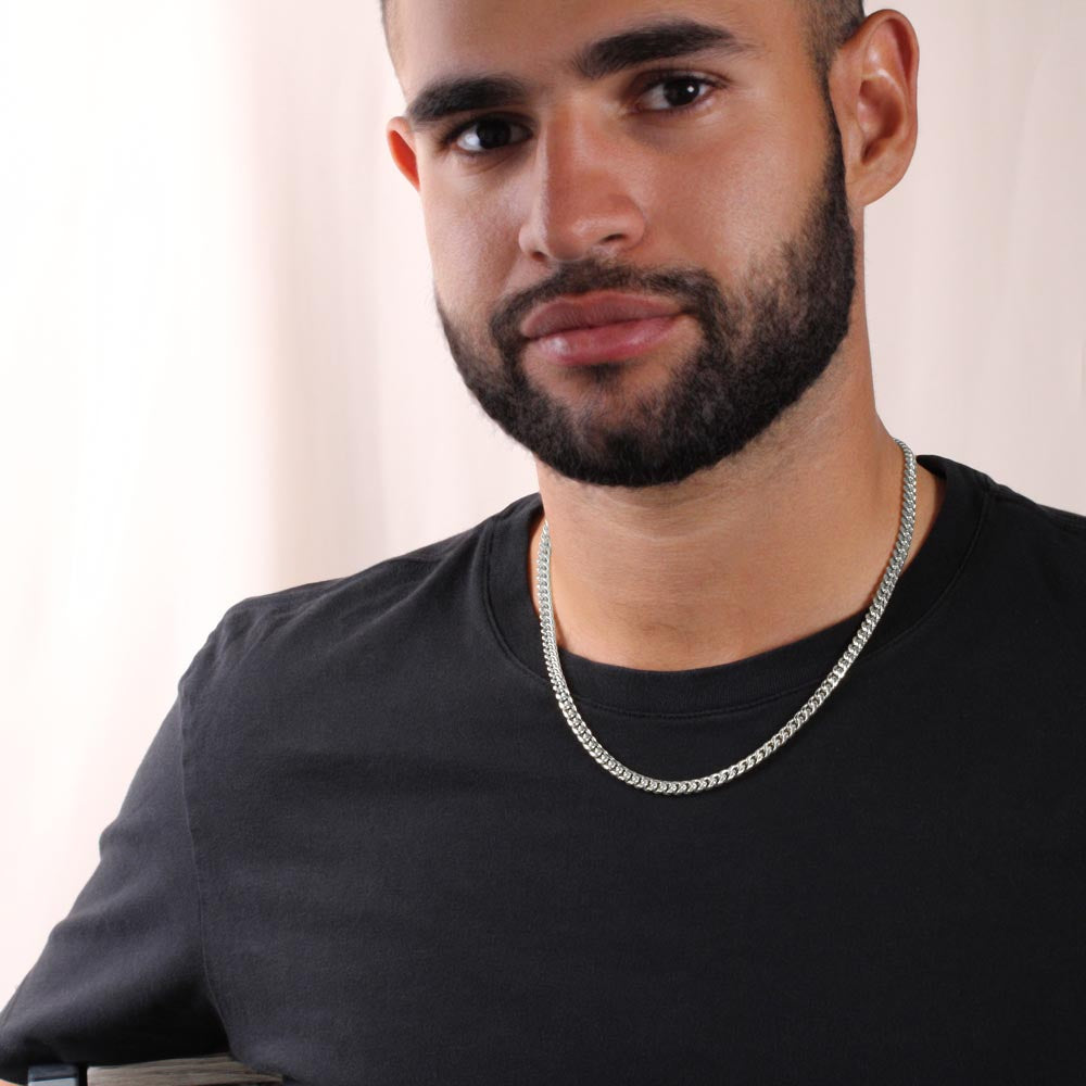 Man wearing stainless steel Cuban link chain necklace over a black sweater