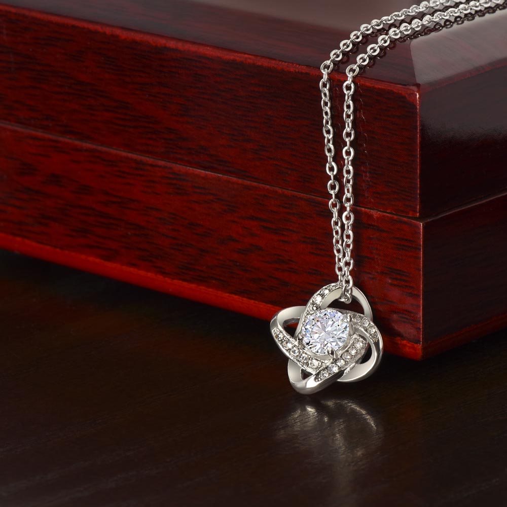 White gold-dipped friendship necklace shown draped over the corner of a luxury mahogany-style gift box