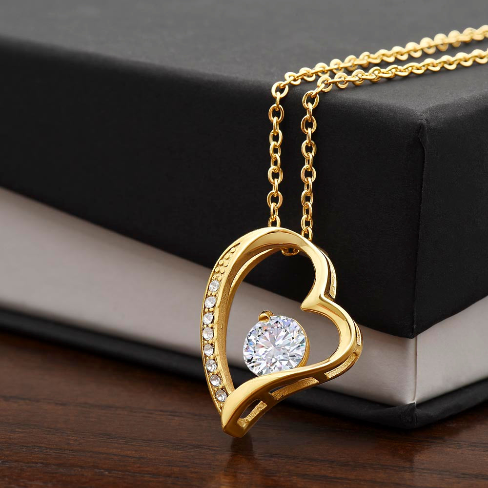 Gold dipped sparkling heart necklace shown draped over the edge of a standard gift box 