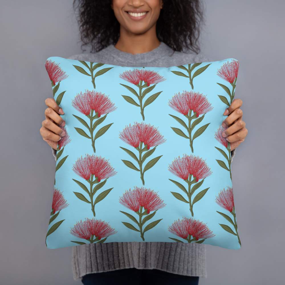 Pohutukawa print cushion with sky blue background being held by a woman