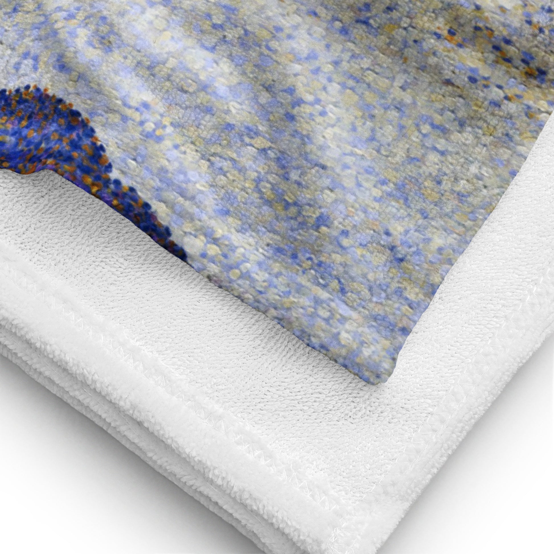 Close-up of corner of beach towel featuring painting 'Evening calm, Concarneau' by Paul Signac, showing detail of picture and texture of fabric.
