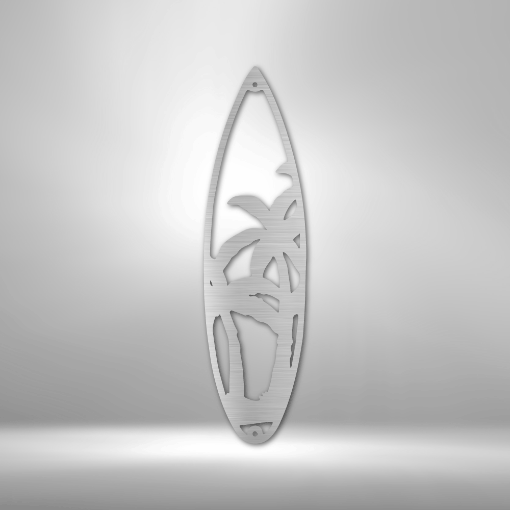 Decorative silver steel sign in shape of a surf board with palm tree design shown in close up